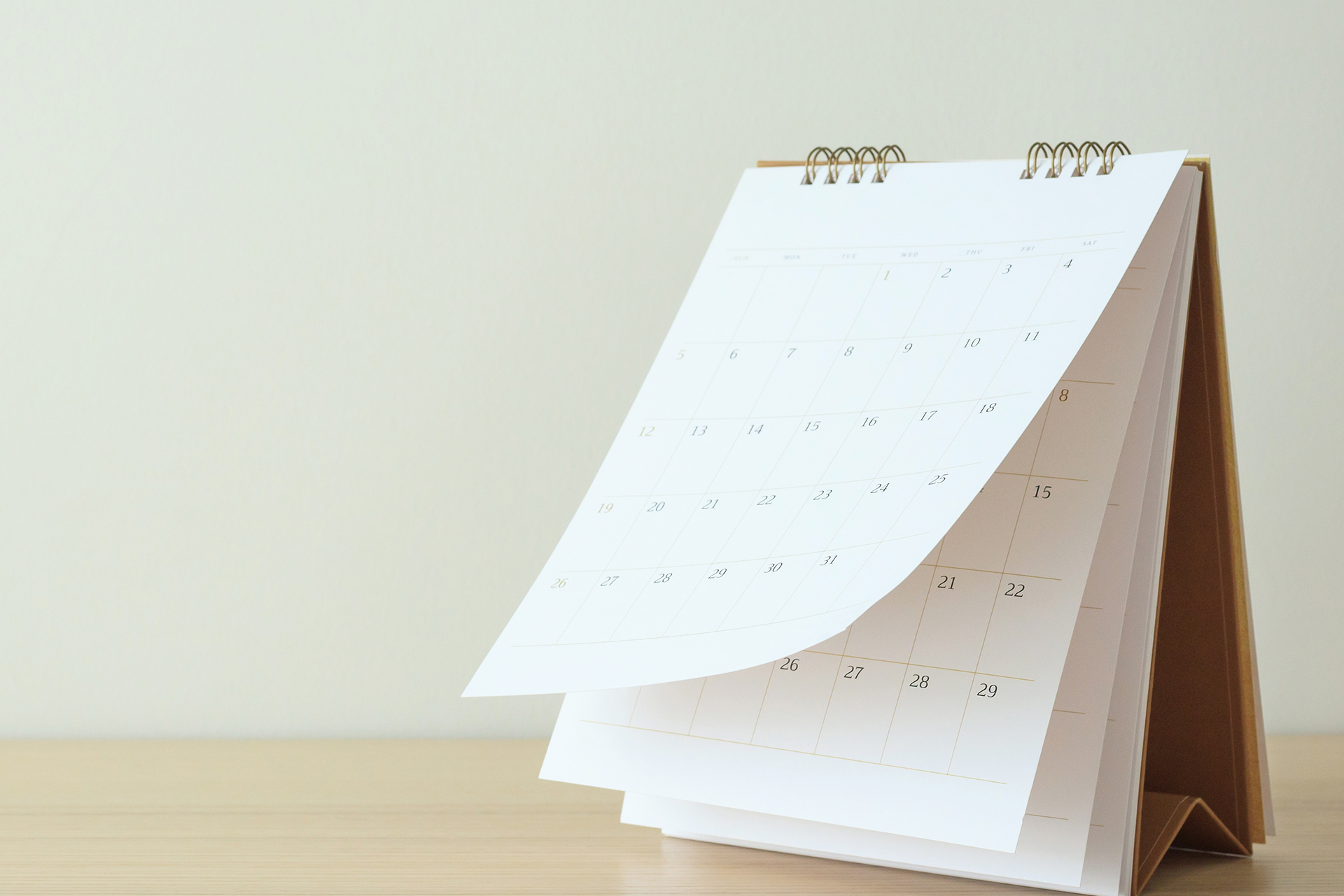 The image shows a white clipboard with a calendar attached to it, placed on a flat surface.